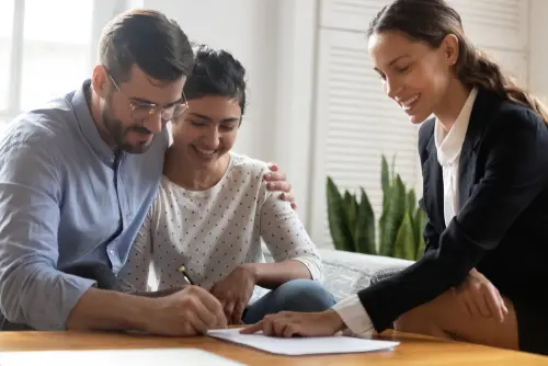 Couple signing life insurance beneficiary paperwork