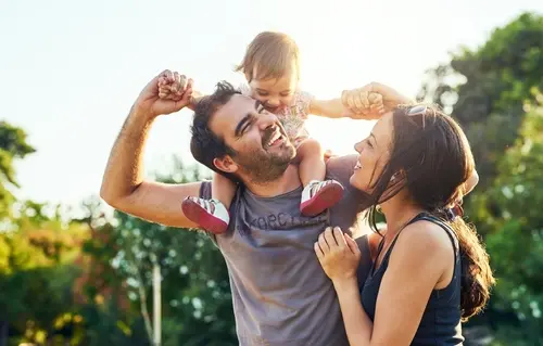 Mom and dad playing with their baby outside